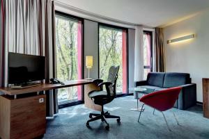 斯图加特斯图加特希尔顿酒店耐卡公园店的酒店客房配有桌椅和电视。