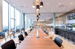 托尔斯港Hilton Garden Inn Faroe Islands的长长的用餐室配有长桌子和椅子