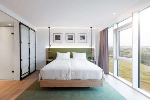 托尔斯港Hilton Garden Inn Faroe Islands的卧室设有白色的床和大窗户