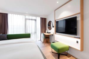 托尔斯港Hilton Garden Inn Faroe Islands的配有一张床和一台平面电视的酒店客房