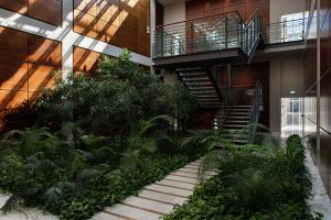 都灵都灵灵格托希尔顿逸林酒店的一座有楼梯和植物的建筑的中庭