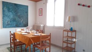 凯恩Maison au calme avec jardin clos的一间带木桌和椅子的用餐室