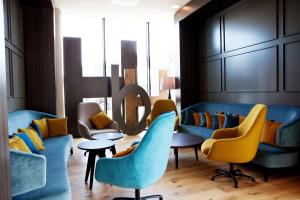 亚琛亚琛蒂沃利汉普顿希尔顿酒店的大堂设有蓝色的沙发和黄色的椅子