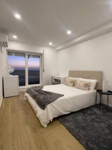 波尔图Quarto duplo com casa de banho exclusiva no Porto的白色的卧室设有一张大床和一个窗户
