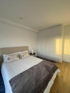 波尔图Quarto duplo com casa de banho exclusiva no Porto的一间卧室设有一张大床和白色的墙壁