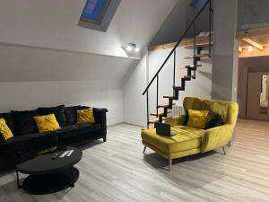 斯维诺乌伊希切Apartamenty Przy Deptaku的带沙发和黄色椅子的客厅