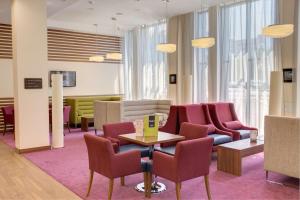 乌法乌法汉普顿希尔顿酒店的一间设有椅子和桌子的等候室