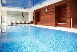 罗兹罗兹希尔顿逸林酒店的大楼内一个蓝色的大型游泳池