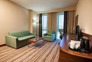埃尔津詹埃尔津詹希尔顿花园酒店的酒店客房设有沙发、椅子和电视。