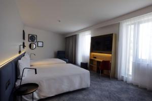 奥尔什丁Hampton By Hilton Olsztyn的酒店客房设有两张床和电视。