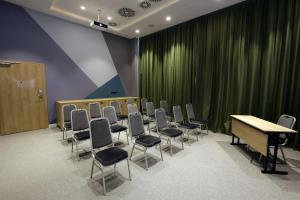 奥尔什丁Hampton By Hilton Olsztyn的一间会议室,配有椅子和桌子,并有绿帘