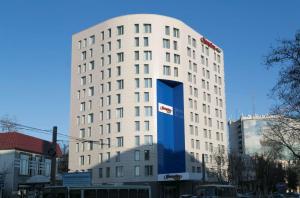沃罗涅什沃罗涅日希尔顿汉普顿酒店的白色的建筑,上面有蓝色的大标志