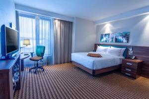 沃罗涅什沃罗涅日希尔顿汉普顿酒店的配有一张床和一台平面电视的酒店客房