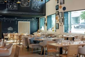 马西Hilton Garden Inn Paris Massy的餐厅设有桌椅和黑板墙