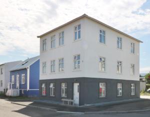 阿克雷里G7 Akureyri Central Apartments的一座白色的大建筑,有蓝色的房子