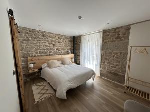 Bermillo de SayagoLA ALCOBA DE SAYAGO的一间卧室设有一张床和砖墙