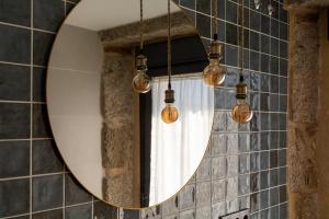 Bermillo de SayagoLA ALCOBA DE SAYAGO的浴室内的镜子,配有灯和窗帘