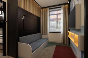 鹿特丹Motto By Hilton Rotterdam Blaak的一间配有沙发、电视和窗户的客房