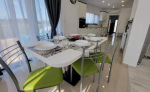 Home Sweet Home的白色的餐桌和绿色椅子