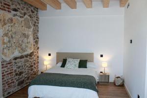 洛索亚河畔布伊特拉戈El Esquileo的卧室配有白色的床和砖墙