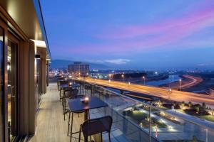 斯科普里DoubleTree By Hilton Skopje的设有带桌椅的市景阳台。