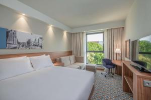 奥斯威辛Hampton by Hilton Oswiecim的酒店客房设有一张大床和一张书桌。