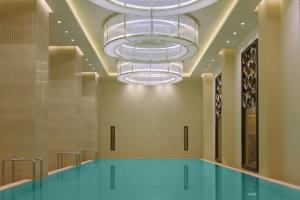 杜尚别Hilton Dushanbe的吊灯房间中的游泳池