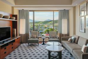 杜尚别Hilton Dushanbe的客厅配有沙发、椅子和电视