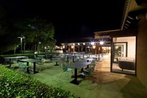 伊斯兰蒂拉DoubleTree by Hilton Islantilla Beach Golf Resort的一群桌子和椅子在晚上在庭院里
