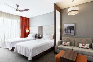 锡劳锡劳机场希尔顿惠庭套房酒店的酒店客房,设有两张床和一张沙发