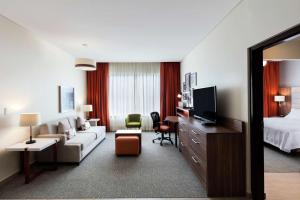锡劳锡劳机场希尔顿惠庭套房酒店的酒店客房设有床和客厅。