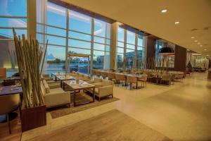 皮拉尔Hilton Pilar的餐厅设有桌椅和大窗户。