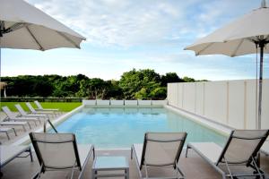 卡门城希尔顿休达德尔卡门汉普顿酒店的一个带椅子和遮阳伞的游泳池
