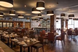 塞拉亚Doubletree By Hilton Celaya的一间带桌椅的餐厅和一间酒吧