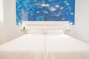 拉雷斯廷加Alojamiento Guayarmina的一间有鱼画的房间的一张白色床