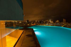 利马利马米拉弗罗尔希尔顿酒店的游泳池,晚上可欣赏到城市美景
