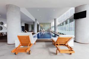 墨西哥城美洲圣塔菲嘉年华酒店的一座带游泳池和两把椅子的房子