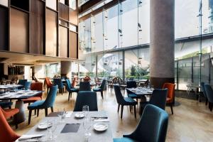 墨西哥城美洲圣塔菲嘉年华酒店的餐厅设有桌椅和窗户。