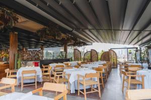 墨西哥城Umbral, Curio Collection By Hilton的餐厅设有白色的桌子和木椅