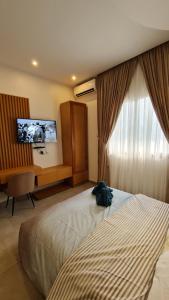 AbagaKBK Lodge的配有一张床、一张书桌和一扇窗户的酒店客房