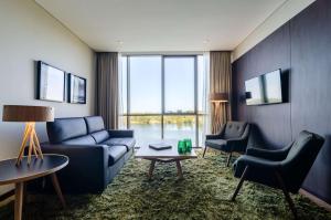 蒙得维的亚汉普顿希尔顿蒙得维亚卡拉斯科酒店的客厅配有蓝色的沙发和两把椅子