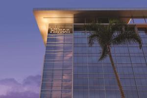 里约热内卢里约热内卢希尔顿巴拉酒店的前面有棕榈树的建筑