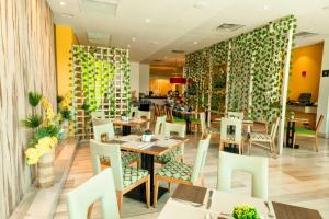 巴兰基亚巴兰基亚希尔顿花园酒店的一间带桌椅和绿色墙壁的餐厅