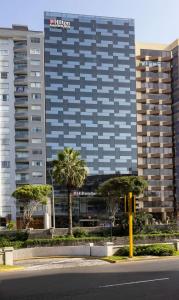 利马Hilton Garden Inn Lima Miraflores的一条街道前方有棕榈树的高楼