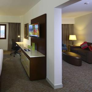 库斯科库斯科希尔顿花园酒店的酒店客房配有一张床、一张书桌和一张沙发。