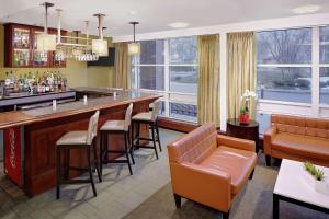 波士顿波士顿海滨希尔顿逸林酒店 的一间酒吧,配有棕色椅子和吧台
