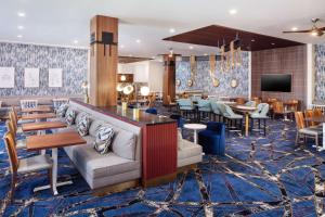 波士顿Hampton Inn Boston Seaport District的酒店大堂设有桌椅和酒吧