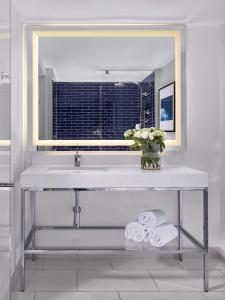 劳德代尔堡劳德代尔堡码头希尔顿酒店 的浴室配有带镜子的盥洗盆和毛巾