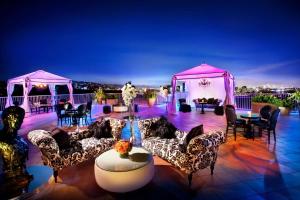 洛杉矶比佛利希尔顿酒店的天井配有沙发、桌子和粉红色的凉亭。