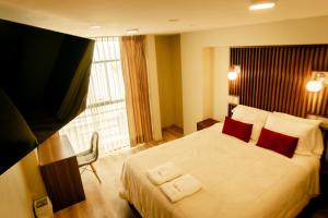 胡利亚卡Hotel California的酒店客房配有一张带红色枕头的大床